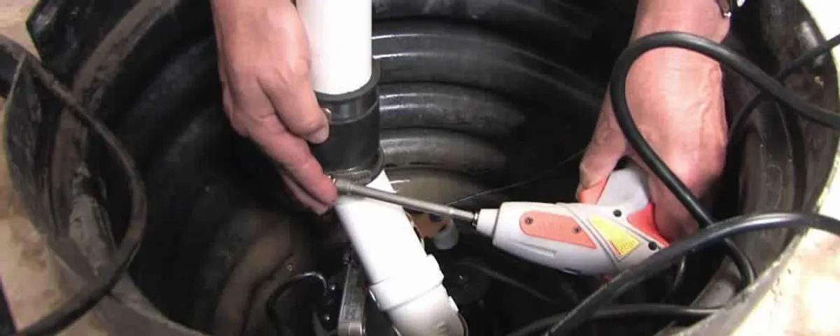 Sump pump installation technician connecting PVC discharge piping in West Palm Beach, FL